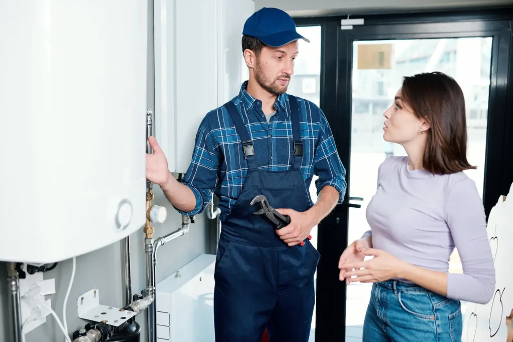 plumber explains work to woman, emergency hot water repair Winston-Salem, NC